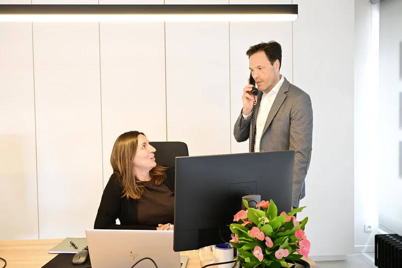 Businessman on phone with woman in modern office