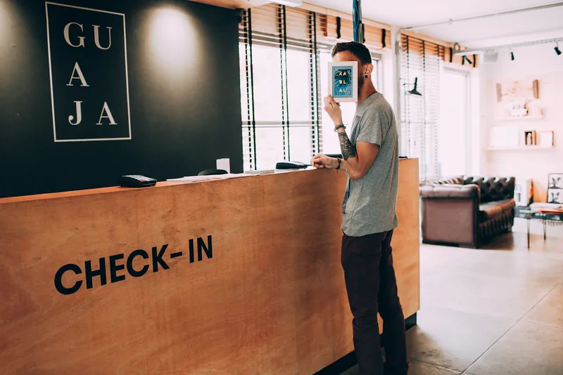 A visitor speaking with a person at a check-in desk