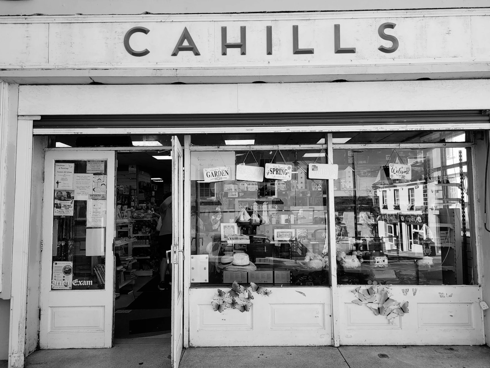The storefront of Cahills with a glass window displaying various items and signs