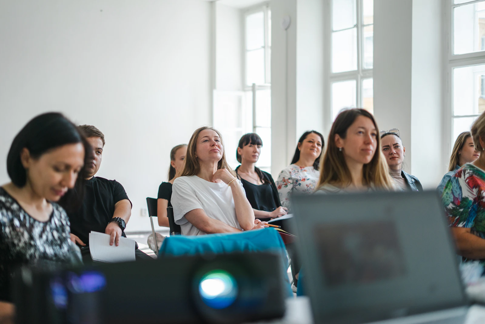 A group of adults attending a workshop in a bright sunlit room