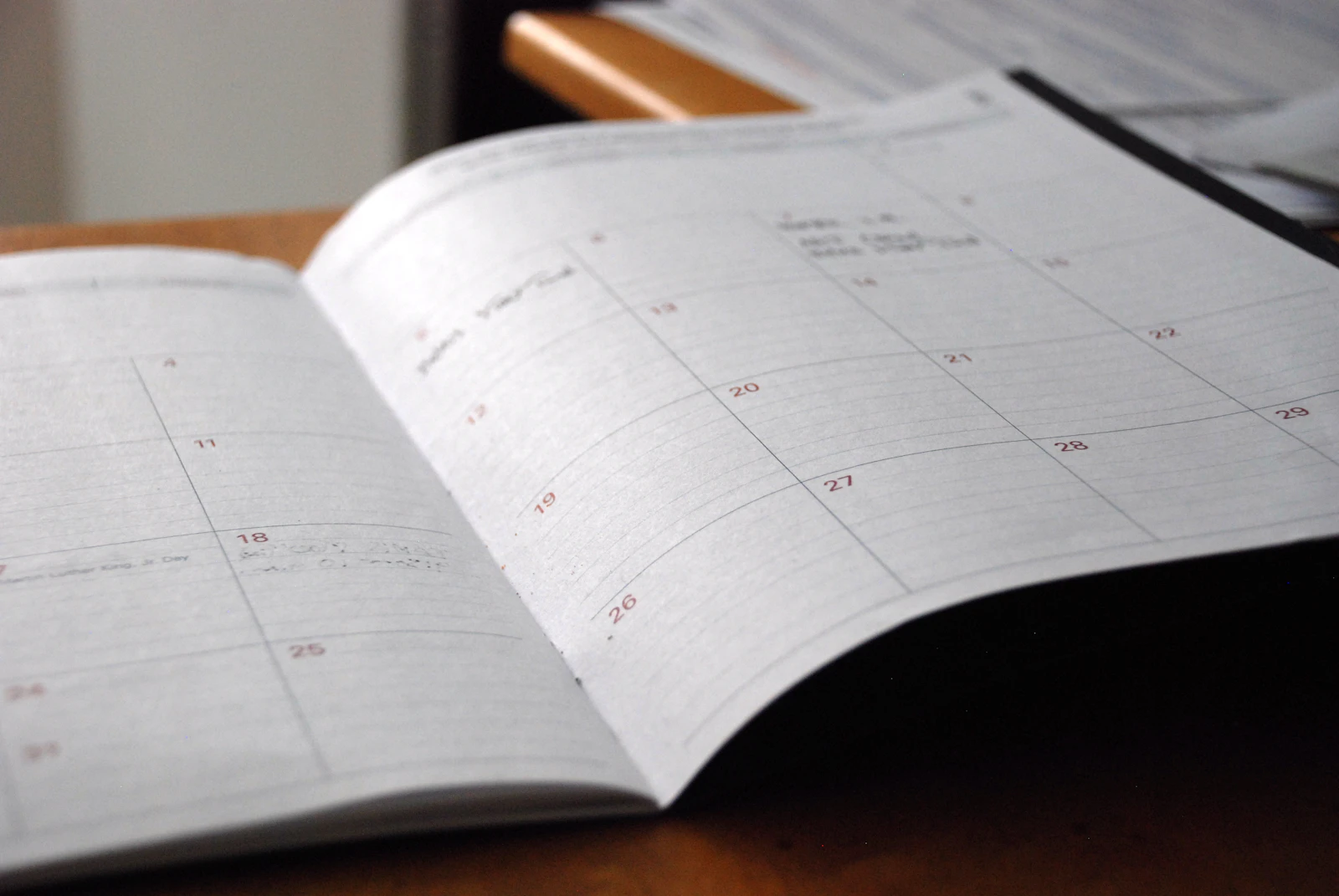 open monthly planner on wooden desk