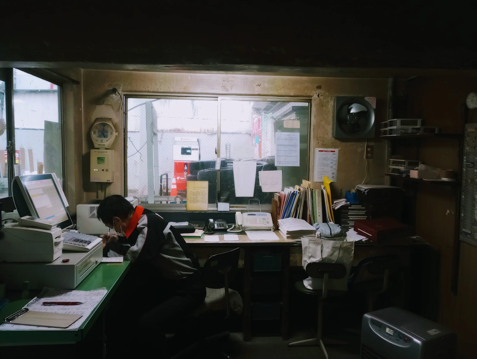 Man working at a cluttered desk with a computer